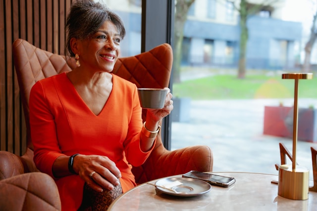 A woman sitting at a table with a cup of coffee